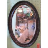 An Edwardian mahogany oval framed wall mirror.