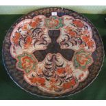 An impressive 19th century Imari charger, having three floral decorated panels on a grey ground,