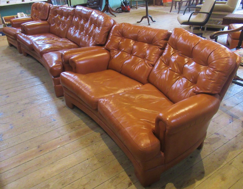 A contemporary tan leather lounge suite comprising three seater settee, two seater sofa,