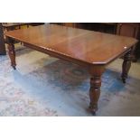 A Victorian mahogany wind out dining table with one extra leaf.