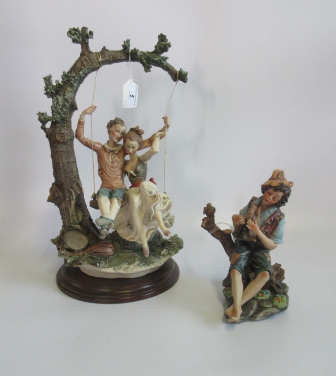 A large Capodimonte figure of a couple on a swing, together with a small Capodimonte figure.