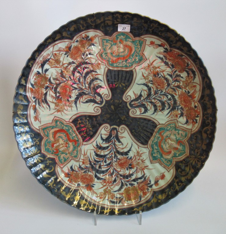 An impressive 19th century Imari charger, having three floral decorated panels on a grey ground,