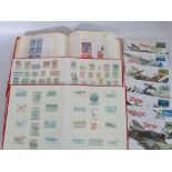 Three albums containing a large quantity of British and all world stamps.