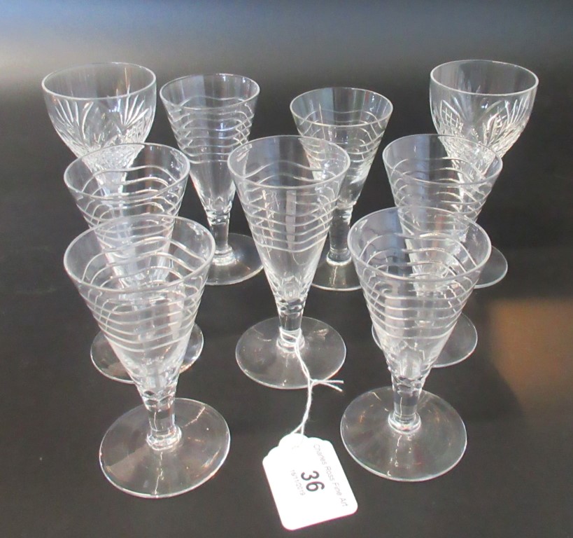 A collection of nine various liqueur glasses.