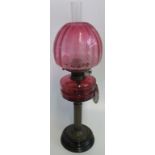 A Victorian oil lamp with cranberry bowl and etch glass cranberry shade.
