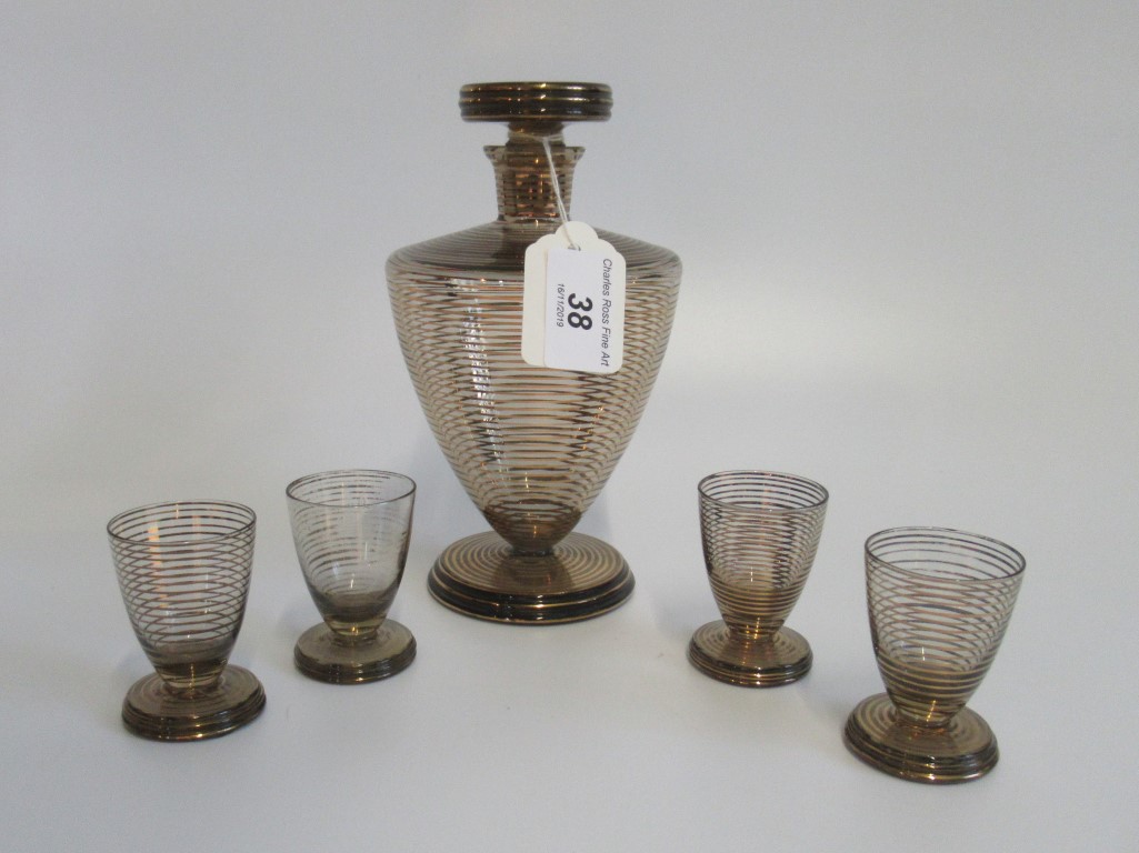 An Art Dec-style black and gold decanter, together with four matching liqueur glasses.