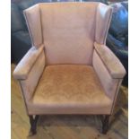 A 20th century oak framed and upholstered wingback fireside chair.