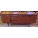 A mid-20th century sideboard, having three drawers flanked by twin cupboard doors,