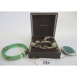 A jade bangle with highly decorated metal mount, a four stone ring, pendant and a bracelet.