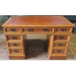 A reproduction yew wood nine drawer pedestal desk.