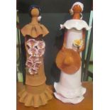 A near matching pair of 20th century pottery figures, the Bolivian faceless ladies.