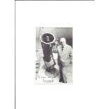 Patrick Moore signed 6x4; black and white image of Sir Patrick stood next to a telescope,