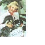 Doris Day signed 6 x 4 colour photo, seated with her two dogs. Comes with biography information.