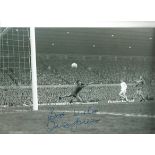 Autographed Mick Jones photo, a superb image depicting the Leeds United centre-forward scoring the