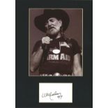 Willie Nelson signature piece. Mounted below b/w photo. Approx overall size 16x12. Good Condition.