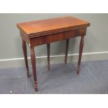 A mahogany foldover top card table on five legs