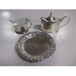 A capstan shaped silver mustard with a silver plated spoon, and an oval silver mustard, both with