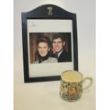 A signed photograph of the Duke and Duchess of York in a leather monogrammed frame, a Coronation mug