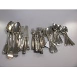 An assortment of silver flatware, including forks and knives with filled handles and silver