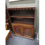 An Edwardian free standing bookcase with two cupboards under, on bun feet, 123cm x 92cm x 29cm,