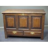 An antique oak mule chest with triple 'linen fold' panelled front above two drawers, 127cm wide