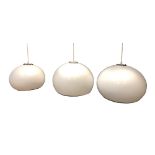 Attributed to Harvey Guzzini, a graduated set of three white acrylic bulbous pendant lights, the