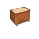 A Cotswold School oak ottoman or shoe box, the hinged rectangular top with rush seat above