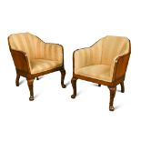 A pair of Art Deco walnut armchairs, the solid angled backs raised on stepped cabriole front legs,