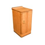 An Art Deco maple bedside cupboard, the rounded rectangular top above brushing slide and single