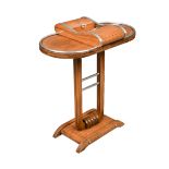 An Art Deco walnut games table, the top with two tambour compartments flanking a central well,