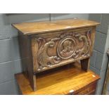 A Reproduction oak boarded chest, with a carved panel front, 52 x 71 x 35cm