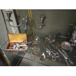 A collection of silver plated items including flatware, candlesticks, toastracks etc