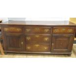 A George III oak dresser base, with five drawers and a pair of cupboard doors, 85 x 181 x 55cm