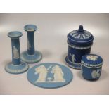 Items of Wedgwood blue jasperware to include a circular plaque, a pair of candlesticks, jugs etc
