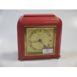 A coral coloured leather covered mantel clock in the Art deco taste retailed by Cameron Cuss and Co