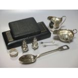 A collection of silverware including a Georgian cream jug, a Georgian basting spoon, a sauce boat, a