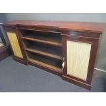 A Victorian mahogany inverted breakfront bookcase with adjustable shelves, flanked by two