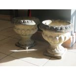 Two pairs of composition garden urns on socle bases, one marked 'Sandford Stone'; the larger pair