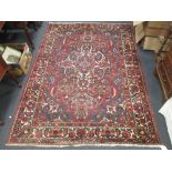 A Persian red and blue ground rug with central floral medalion 220 x 160cm