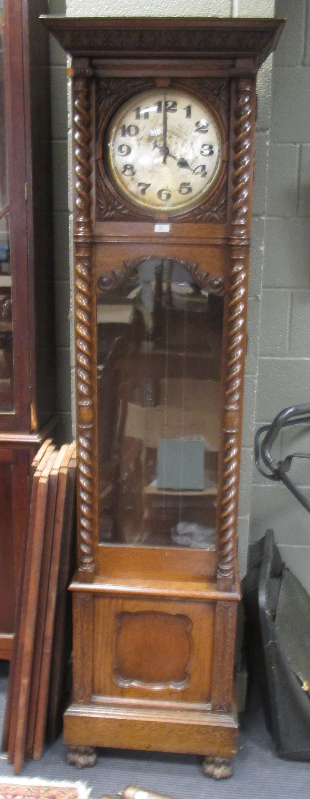 An 8 day oak longcase clock with barley twist column supports on paw feet 201cm high