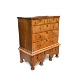 An early 18th century oak and walnut chest on stand, with veneered drawer fronts and brass pear-drop