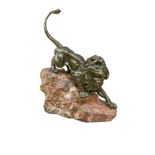 Giacomo Merculiano, (Italian, 1859-1935), a bronze model of a lion, modelled stalking down a red