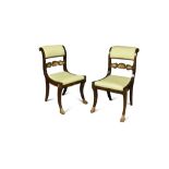 A pair of Regency parcel gilt faux rosewood dining chairs, with scrolling back rails, drop-in