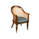 A Regency faux rosewood bergere library chair, with fern, scroll and quarter fan carved