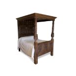 A 16th century and later oak tester bed, with carved arcaded panels to the head and foot boards,