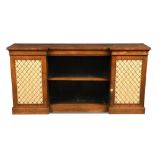 A Regency rosewood breakfront side cabinet, with brass grill and silk lined doors and open shelves