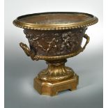 A 19th century twin-handled bronze urn or wine cooler, the oval form with a continuous patinated