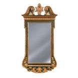 A parcel gilt framed wall mirror in the manner of William Kent, with scrolling shaped pediment and