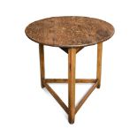 An 18th century oak cricket table, the circular plank top on three stretchered legs 71 x 72cm (28