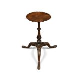 An 18th century mahogany urn stand, the circular top with a crenellated border, on a turned column